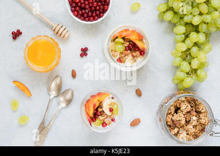 Gesundes Frühstück essen Tabelle: Müsli, Obst, Joghurt und Honig. Tabelle Ansicht von oben Stockfoto