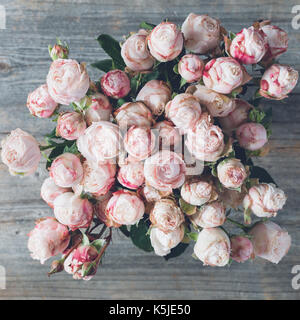 Rosa strauch Rosen Blumenstrauß der Hochzeit Blumen auf hölzernen Hintergrund. Detailansicht. Vintage Retro Ton. square Erntegut Stockfoto