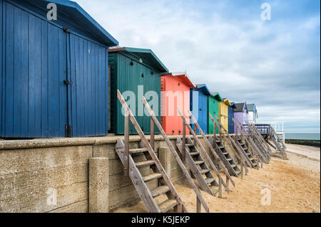 Zeile der hölzernen Umkleidekabinen am Strand an der Walton auf der Naze, Essex, Großbritannien Stockfoto