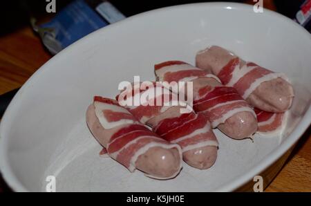 Schweine in Decken, Speck und Würstchen essen Vorbereitung und Hausmannskost. Exeter, Devon, Großbritannien. 2017. Stockfoto