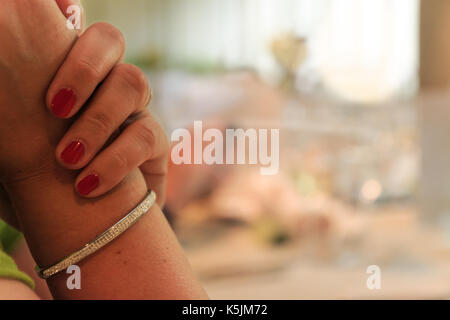 Bis auf die weibliche Hand mit roten polierte Nägel auf einer Party Tabelle Stockfoto