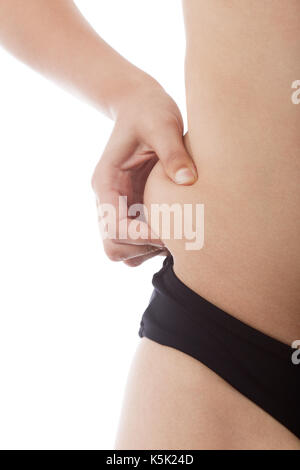 Frau zeigt Fett auf dem Bauch auf weißem Hintergrund Stockfoto