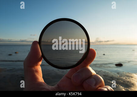 Mann mit Farbverlauf Neutral Density ND-Filter auf dem Hintergrund der Sommer Sonnenuntergang Stockfoto