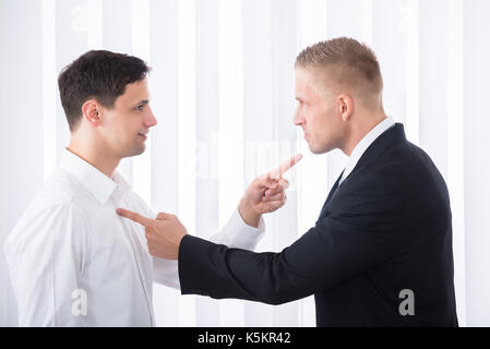 Porträt von zwei jungen Unternehmer zeigenden Finger an jeder anderen Stockfoto