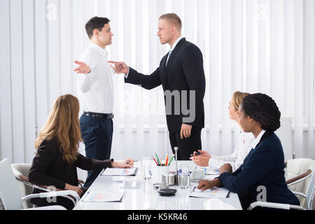 Gruppe von Geschäftsleuten auf Geschäftsmann Schuld sein Kollege in Sitzung Stockfoto