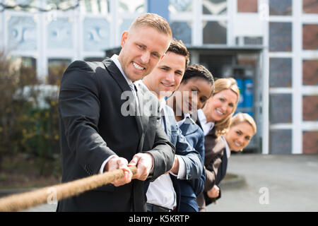 Gruppe von Happy multiethnischen Menschen spielen Tauziehen Stockfoto