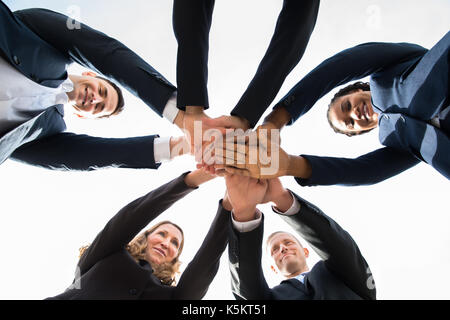 Low Angle View der multi-ethnischen Geschäftsleute, die Hände übereinander stapeln Stockfoto