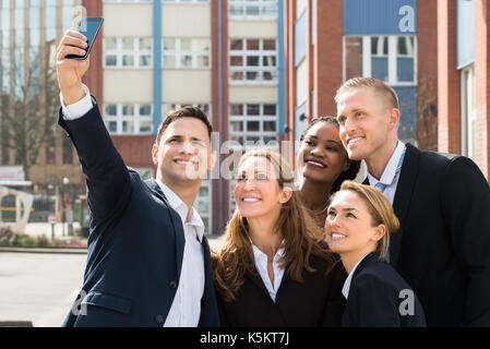 Gruppe von Geschäftsleuten, die selfie mit Handy Stockfoto