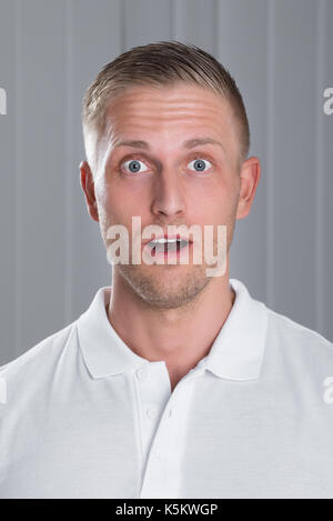 Portrait von Überrascht jungen gutaussehenden Mann im weißen T-Shirt Stockfoto