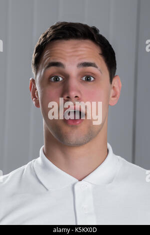 Portrait von Überrascht jungen gutaussehenden Mann im weißen T-Shirt Stockfoto