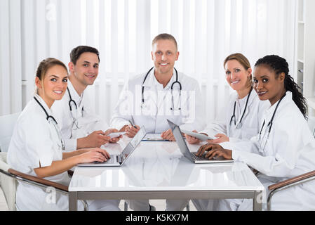 Team von Happy Ärzte mit digitalen Tablet-PC und Laptop in der Sitzung Stockfoto