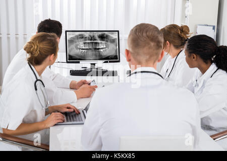 Gruppe von Ärzten an Zähne X-ray auf dem Computer Desktop im Krankenhaus Stockfoto