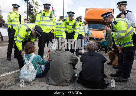 London, Großbritannien. 9. September 2017. Polizisten fordern die Demonstranten, die sich in eins der Zufahrtswege durch Lkw zum Einsatz militärischer Ausrüstung in der nächsten Woche DSEI arme Messe im ExCel Center zu liefern, die Autobahn zu löschen saß. Aktivisten aus vielen verschiedenen Kampagne und glauben Gruppen protestierten außerhalb des ExCel Centre gegen den Waffenhandel und die Arme fair. DSEI ist die weltweit größte Messe Waffen und militärische Delegationen durch die britische Regierung eingeladen, gehören Staaten durch das Auswärtige Amt benannt als "Menschenrechte Priorität', nämlich Bahrain, Kolumbien, Ägypten, Pakistan und Saudi-Arabien. C Stockfoto