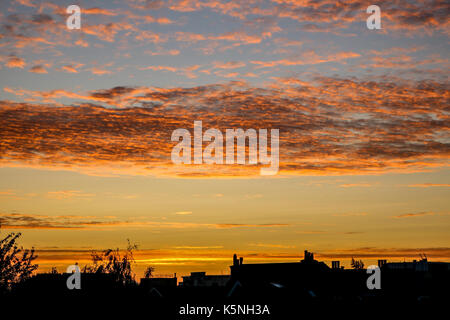 London, Großbritannien. 10. September 2017. Wohn- Dachterrasse Gebäude sind gegen einen schönen Herbst Sonnenaufgang mit farbigen Wolkenformationen in Wimbledon Credit Silhouette: Amer ghazzal/Alamy leben Nachrichten Stockfoto