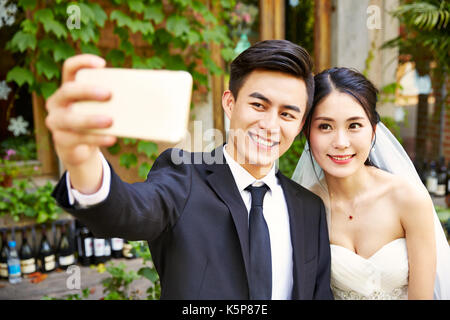 Junge asiatische Braut und Bräutigam ein selfie mit Handy. Stockfoto