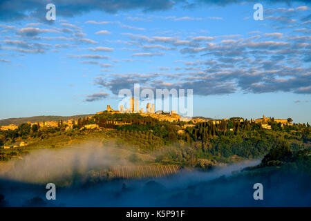Die Skyline von San Gimignano, auf einem Hügel, ist das aus dem Morgennebel Stockfoto