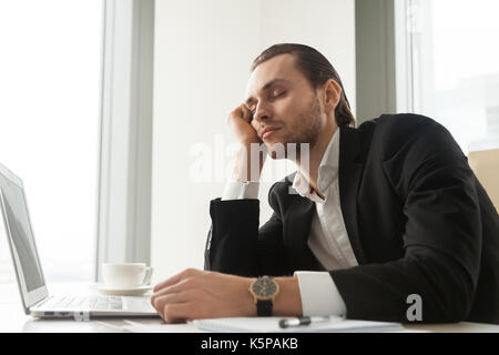 Junge Unternehmer döste vor Laptop zu arbeiten. Stockfoto