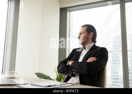 Verträumt lächelnd gut aussehender Geschäftsmann denken über Corporate fut Stockfoto