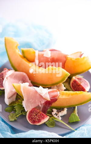 Reif süß Melone mit Schinken, figgs und Rucola Stockfoto