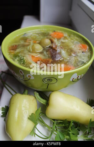 Appetitliche vegetarische Suppe von Kohl in Ton grün Schüssel mit Pfeffer und Petersilie dekoriert Stockfoto