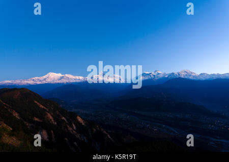 Die schneebedeckten Gipfel der Annapurna Himalaya Gebirge beleuchtet durch die frühe Morgendämmerung Sonnenlicht von Sarangkot, Nepal gesehen Stockfoto