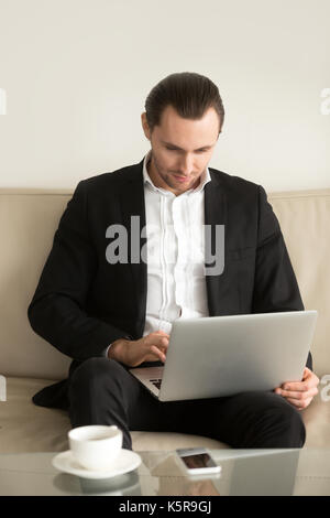 Geschäftsmann auf Laptop fern von zu Hause aus arbeiten. Stockfoto