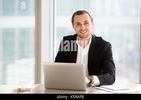 Portrait von Stattlichen lächelnd Geschäftsmann bei der Arbeit im Büro. Stockfoto