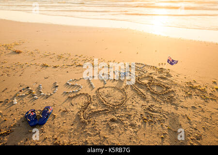 Australien 2018 Text mit Tangas und Sonnenbrille am Strand bei Sonnenuntergang Stockfoto
