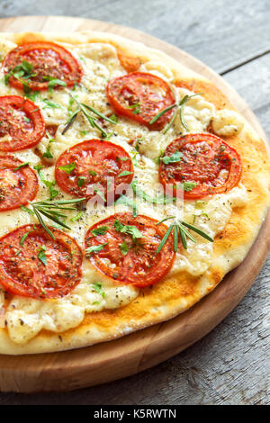 Pizza Margherita mit Tomaten, Käse, Basilikum und Rosmarin. Hausgemachte thin vegetarische Pizza. Stockfoto