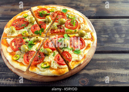 Würzige mexikanische Pizza mit Tomaten, Oliven und jalapeno Pfeffer. Vegetarische Pizza mit Oregano. Stockfoto