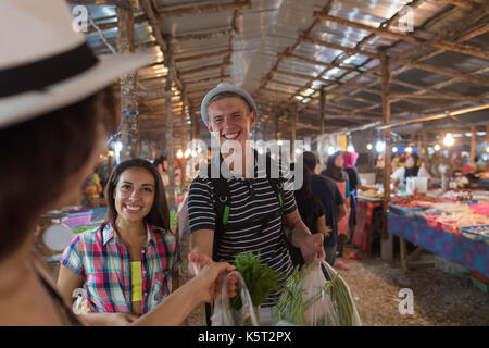 Touristen auf tropischen Street Market in Thailand junge Menschen Kaufen Frisches Obst und Gemüse Stockfoto