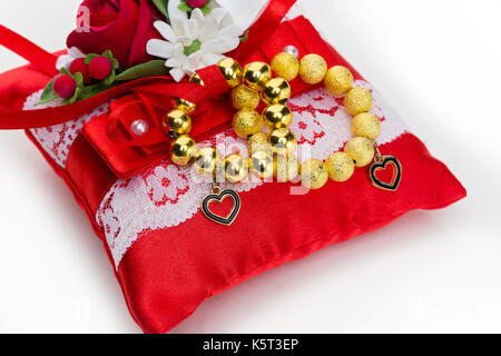 Kissen mit goldenen Perlen Armband Ringe Stockfoto