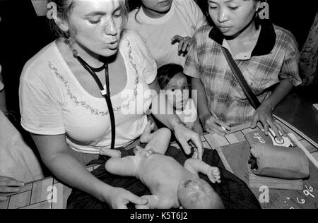 Dr. Mary Washburne untersucht ein Kind links im Wald an ist Geburt (mit Plazenta) an Shok La Flüchtlingslager im Nordwesten von Thailand; ein Lager nur für diejenigen mit Cholera Symptome zu sterben. September, 1996. Stockfoto