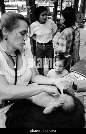 Dr. Mary Washburne untersucht die burmesischen Flüchtlinge Säugling bei Shok La Flüchtlingslager im Nordwesten von Thailand; ein Lager nur für diejenigen mit Cholera Symptome. Das Kind wurde in den Wald geboren und Links zu sterben (Plazenta). September, 1996. Stockfoto