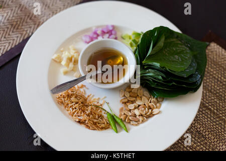 Beliebte Thai snack Miang Kham aus betelblatt, Ingwer, Zwiebel, Limone, Kokosnuss, Erdnüsse, Vogelperspektive chili und Honig. Bild von traditionellen thailändischen cuisin Stockfoto