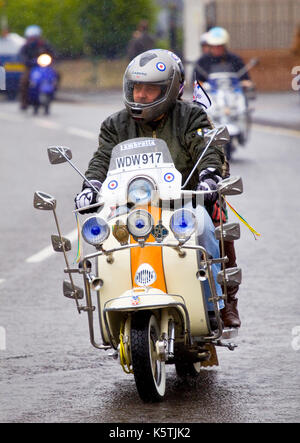 Ein Mod, der während einer organisierten Scooter-Rallye in weston Super Mare, England, einen modifizierten Roller auf einer Straße reitet Stockfoto