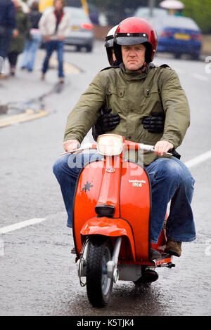 Ein Mod, der während einer organisierten Scooter-Rallye in weston Super Mare, England, einen modifizierten Roller auf einer Straße reitet Stockfoto