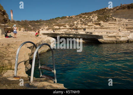 MARSAXLOKK, MALTA - 21. AUGUST 2017: Baden und Entspannen bei Saint Peter's Pool, eine natürliche Rocky Golf in der Nähe des Meeres in Malta Stockfoto