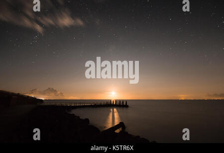 Geschossen wurde, während der Mond am Afsluitdijk auf dem ijselmeer Seite der Straße genommen. Eine schöne Komposition mit Sternen und dem weichen gelben Mond Licht. Stockfoto