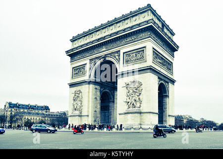 Das triumphbogen-Denkmal steht am Place charles de gaulle in paris, mit Fahrzeugen und Fußgängern um den Fuß. Stockfoto