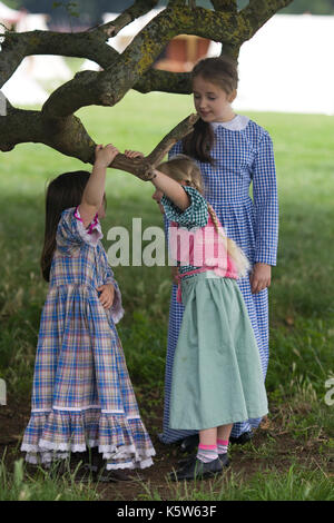 Mädchen Schwingen auf einem Zweig in Tracht an einem Reenactment Stockfoto