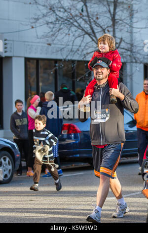 OISE, IDAHO - November 22, 2012: der Mann, der mit einem Ihrer Kinder während der Boise Türkei Tag 5k. Stockfoto