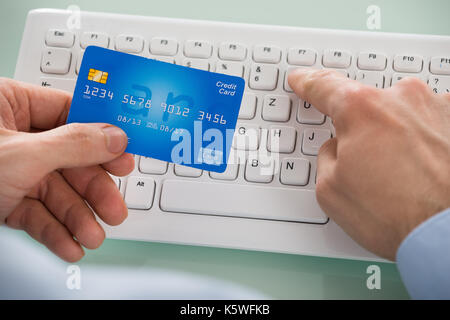 In der Nähe der Person Hand Auto, während über die Tastatur Stockfoto