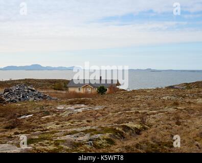 Moderne steinigen Familienhaus auf der Feder am Meer, Norwegen, Island. Ein traditionelles Steinhaus mit einem wunderschönen Blick auf das Meer. Felsige Landschaft mit Stockfoto