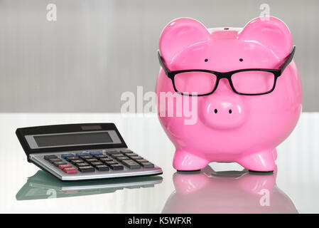 Close-up, ein Sparschwein mit Brillen und Rechner Stockfoto