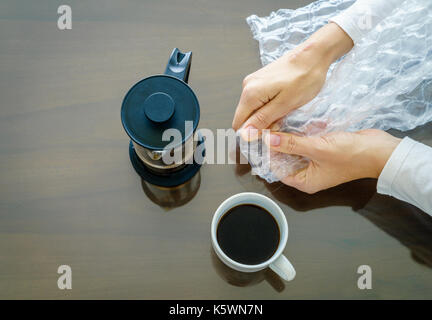 Close-up-Bild der Frau Hände knallen Luftpolsterfolie. Ansicht von oben Stockfoto