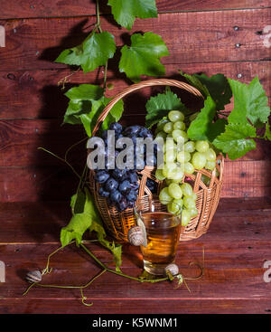 Traubensaft in einem Glas auf einem Tisch mit Trauben und Wein Stockfoto