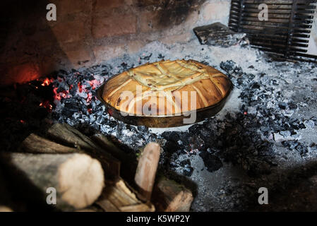 Frisch Brot gebacken in einem Feuer Brot Backofen Umgeben von brennenden Feuerzeug Stockfoto