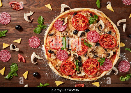 Köstliche italienische Pizza serviert auf hölzernen Tisch Stockfoto