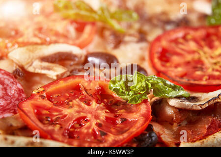 Nahaufnahme von Pizza mit Salami, Tomaten und Oliven Stockfoto